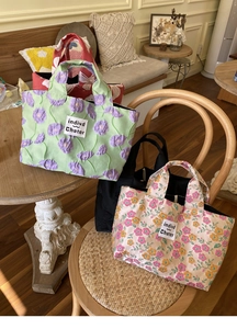 Detail of floral embroidery on cotton tote bags in varied colors and textures