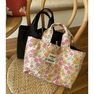 French style red bow handbag and floral tote bag on a wooden chair for elegant daily use