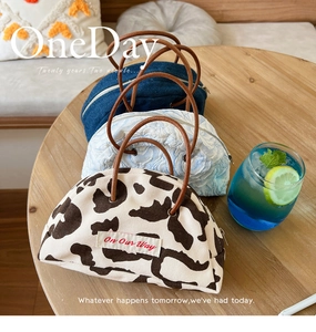 Detailed close-up of denim and jacquard semicircular handbags on a wooden table