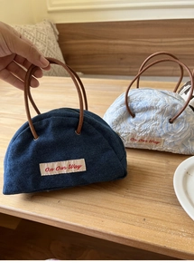 Detail of denim and floral fabric cosmetic bags with brown faux leather handles