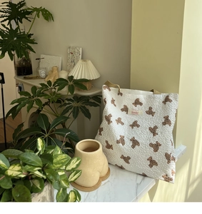 Close-up of quilted bear pattern tote bag with Sonder label and brown handles