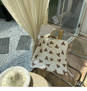 Detail of the embossed bear pattern fabric and yellow straps on the stylish tote bag