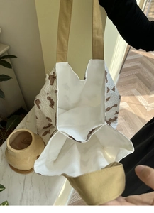 Detail view of large white canvas tote bag with brown bear patterns and spacious interior