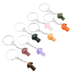 Mixed natural gemstone mushroom keychains with rose quartz and tiger eye on white background