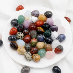 Polished egg-shaped natural agate and crystal semi-precious stones in a ceramic tray