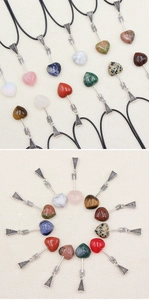 Macro shot of assorted natural crystal heart pendants with vintage silver cupid arrows