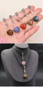 Macro view of natural crystal heart pendants with silver arrow clasps and wax cord