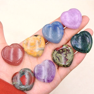 Set of eight diverse 30mm natural heart crystals in hand, polished and smooth for healing