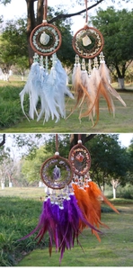 Detail of dream catcher hangings featuring natural crystals and vibrant feathers
