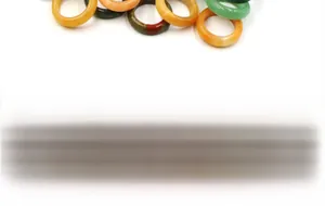 Close-up of polished natural stone rings in various colors like agate and tiger eye