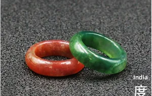 Macro detail of polished green aventurine and red agate gemstone rings from India