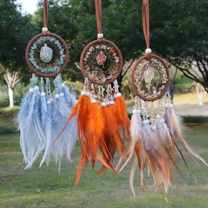 Bohemian dream catcher set with natural crystals and feathers hanging in a garden