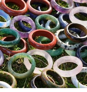 Detailed view of assorted natural crystal rings displayed on moss background