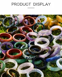 Detailed collection of assorted natural crystal and agate rings on moss background
