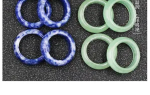 Macro shot of assorted natural stone rings in blue and green textures on black foam