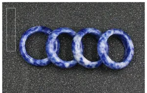 Detailed view of four natural sodalite stone rings with unique blue and white marble patterns
