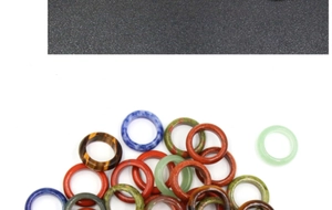 Detailed view of assorted natural stone rings including tiger eye and green aventurine