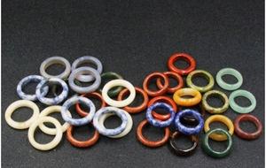 Detailed close-up of colorful natural stone rings featuring smooth polished agate and onyx