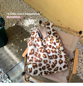 Detail shot of plush leopard print tote bag with blue checkered lining on outdoor chair