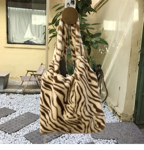 Detail of zebra print plush tote bag showing soft faux fur texture and large capacity