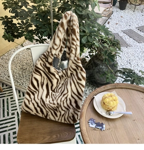 Detail of plush zebra print tote bag with soft faux fur texture and checkered lining