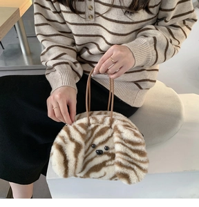 Detailed macro view of fuzzy striped plush puppy bag featuring a soft faux fur texture