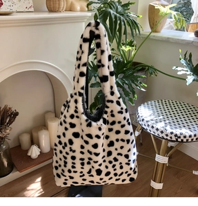 Detail of plush cow print tote bag showing soft texture and checkered lining with snap