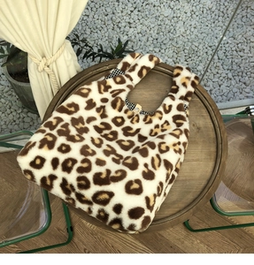 Close-up of leopard print plush tote bag showing soft faux fur and plaid lining