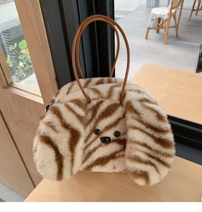 Detail of furry zebra pattern puppy handbag with long ears and brown leather handles