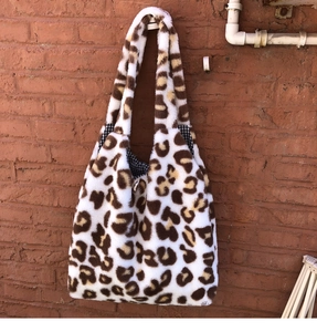 Detail of the leopard print plush tote bag with a soft texture and checkered inner lining