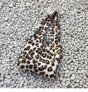 Detail of leopard print plush tote bag with snap closure and checkered inner lining