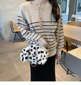 Detail of dalmatian plush bag with silver chain strap and brown leather handle