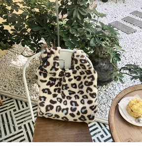 Macro detail of the plush leopard print tote bag fabric and soft texture in a cafe setting