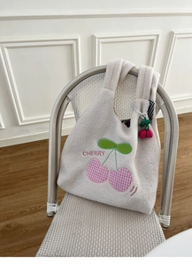 Close-up of fluffy white fleece tote bag with pink heart cherry embroidery and charm
