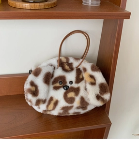 Close-up of plush leopard print handbag with cute animal face and brown leather handles
