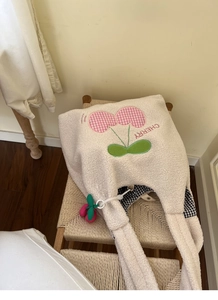 Detail of plush lamb wool tote with cherry embroidery and black checkered lining