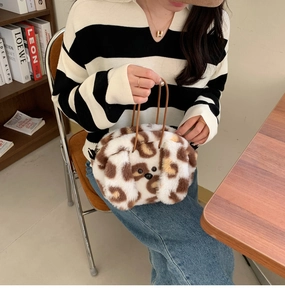 Plush leopard spot handbag showing fluffy texture and brown rope handle in lifestyle setting