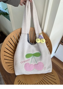 Detail of white sherpa tote bag with cherry embroidery and black checkered lining