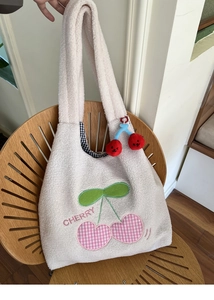 Detail of plush lamb wool tote bag with heart cherry embroidery and checked lining