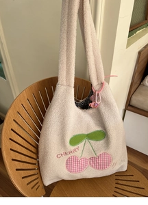 Detail of plush cream lambwool tote bag with cherry embroidery and pink bear charm