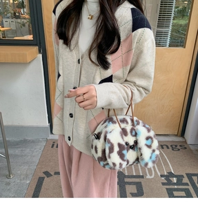 Detail of furry puppy handbag featuring spotted pattern and long animal ear design