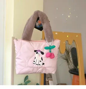 Detail of pink quilted tote bag featuring cute dog embroidery and plush cherry charm