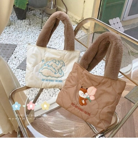 Detail of quilted tote bags featuring cute sheep and fox embroidery with faux fur handles