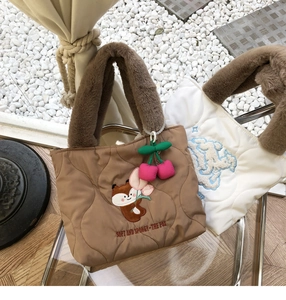 Close-up of quilted coffee tote bag with fox embroidery and brown faux fur handle