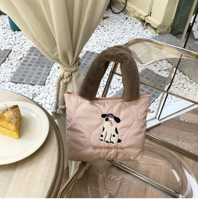 Detail of pink quilted bag with heart texture, plush brown handle and dog embroidery