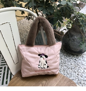 Detail of pink quilted tote bag featuring cartoon dalmatian embroidery and plush brown handles