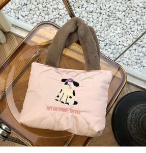Close-up of pink quilted heart bag featuring fluffy brown handles and dog embroidery