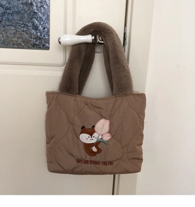 Detail of quilted khaki tote bag with cute fox embroidery and brown plush handles