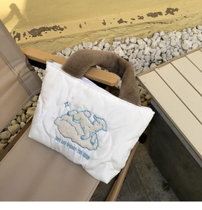 Close-up of white quilted tote bag featuring a cute sheep embroidery and brown fur handle
