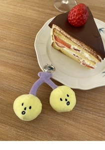 Detail eines flauschigen Kirsch-Schlüsselanhängers auf einem Holztisch